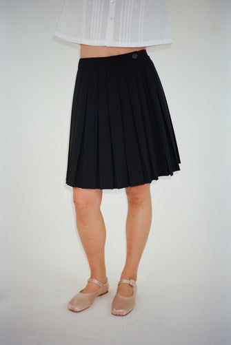 Pleated knee length skort in black on model