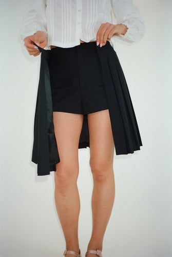 Pleated knee length skort in black on model