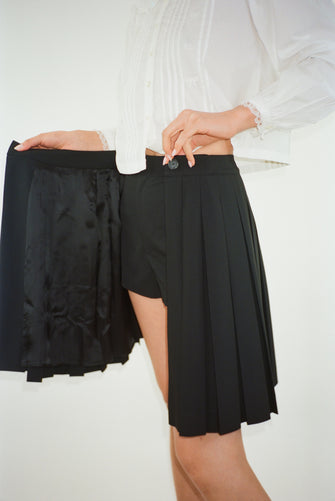 Pleated knee length skort in black on model