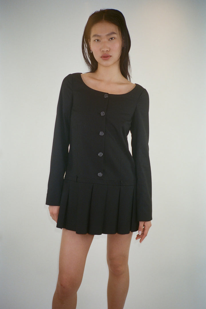 Long sleeve mini dress in black suting with buttons and pleats on model