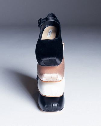 Stack of multi colored ballet flats with dramatic lighting against a white background