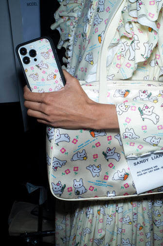 person holding cell phone with yellow bunny print pattern phone case