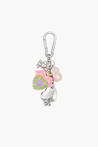 A silver keychain with assorted charms including a heart, a bow, and a floral pattern against a white background