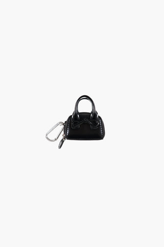 Black handbag with a keychain on a white background