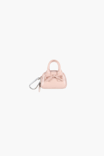 Small pink handbag keychain with a bow on a white background