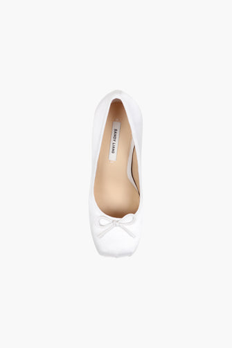 A single white satin pump with a stacked leather heel on a plain background.