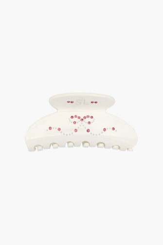 White hair clip with pink rhinestone detail on a white background