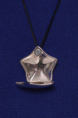 Close up of a silver star-shaped pendant locket open against a blue background
