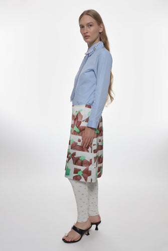 model wearing blue shirt and white satin midi skirt with folding origami photo pattern