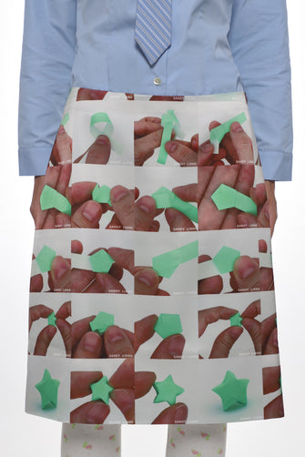 model wearing blue shirt and white satin midi skirt with folding origami photo pattern