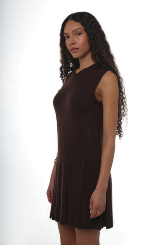 Woman wearing a knit sleeveless brown dress on a white background