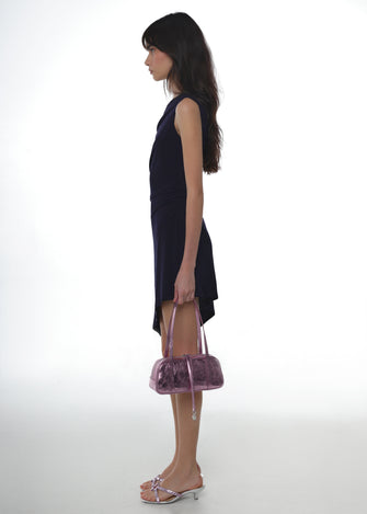 Woman in a black dress holding a pink handbag on a white background
