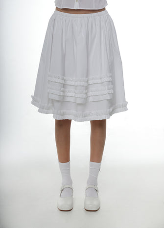 White cotton skirt with ruffles worn by a person on a white background