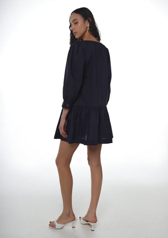 Woman wearing a navy dress on a white background
