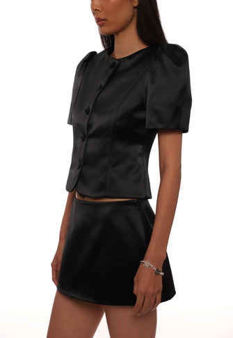 Black satin set with short puff sleeve jacket and and mini skirt on a white background