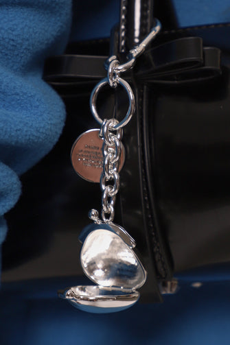 silver keychain on black leather bag
