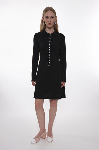 Woman wearing a black dress with buttons on a white background
