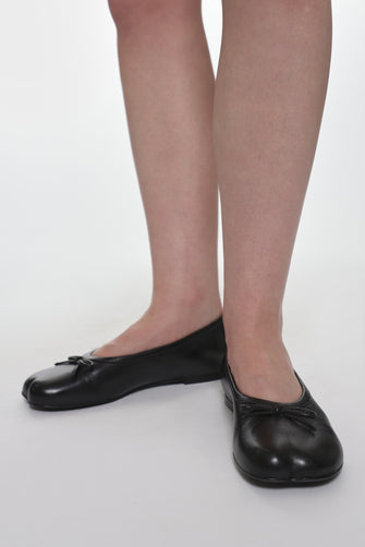 model wearing black leather ballerina flats