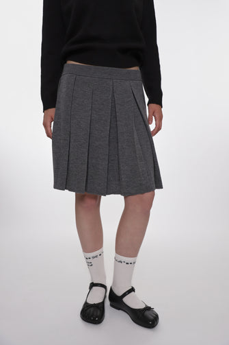 model wearing grey mid length knit pleated skirt