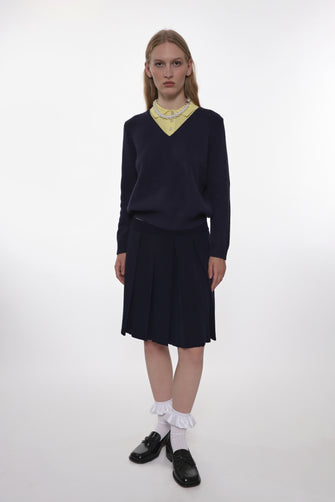 model wearing a navy mid length knit pleated skirt