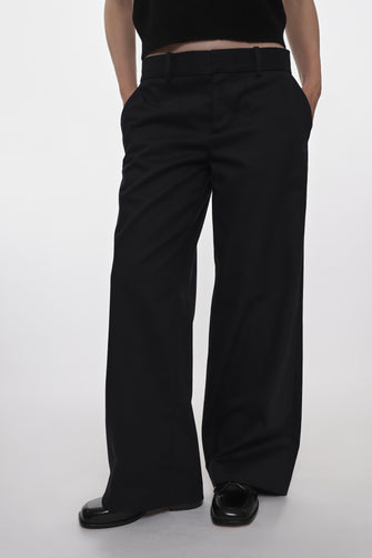 Person wearing black wide-leg pants on a white background