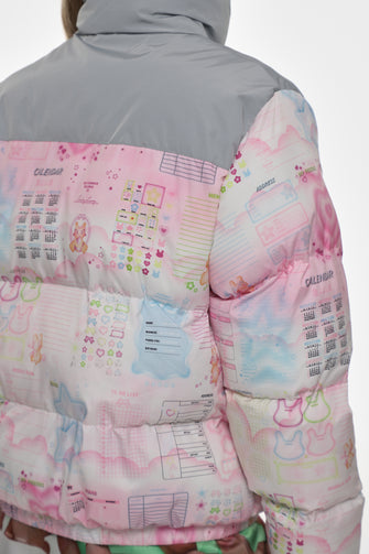 Close-up of a colorful puffer jacket with cartoon designs on a white background