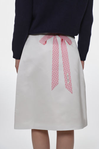 White skirt with a pink ribbon on a white background
