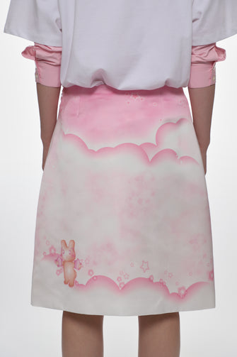 White tshirt layered over pink shirt and a matching pink skirt with cloud design on a white background