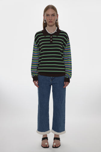 Person wearing a striped sweater and blue jeans on a white background