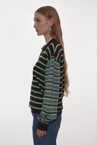 Side view of person wearing a striped sweater against a white background