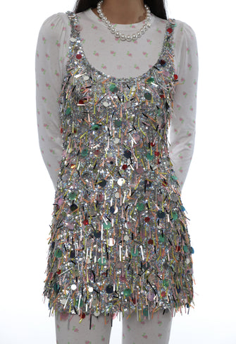 Multicolored sequin dress over a sheer white top on a white background
