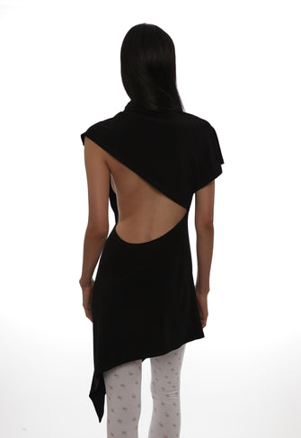 Person wearing a black asymmetrical sleeveless dress with cut-out design on a white background