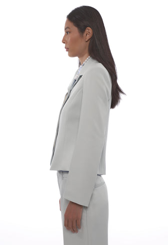 Woman wearing a light blue suit on a white background