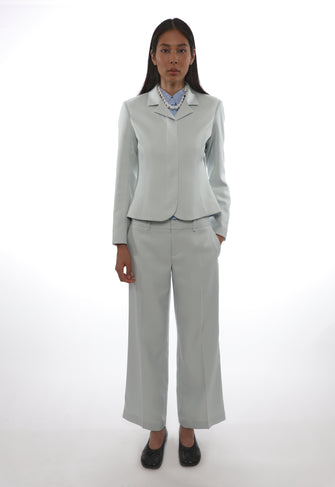Person wearing a light gray suit on a white background