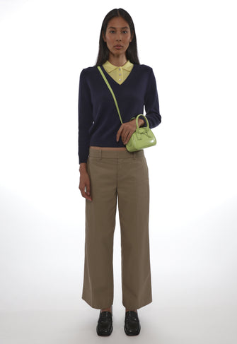 Woman holding a green handbag against a white background