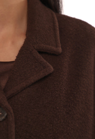 Close-up of a brown coat with a collar and button detail on a white background