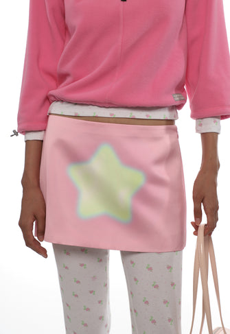 Person wearing a pink outfit with a star-shaped pouch.