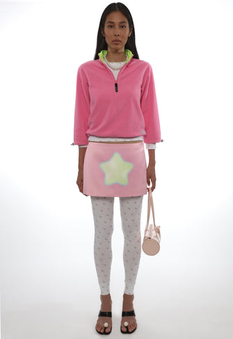 Person wearing a pink fleece jacket with a star design on a white background