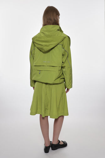 Person wearing a green jacket and skirt set on a white background