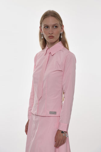 Woman wearing a pink shirt with matching skirt with a white background