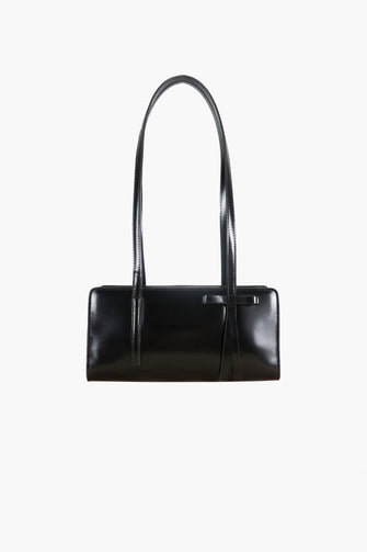 A black rectangular handbag with a bow detail on the side against a white background