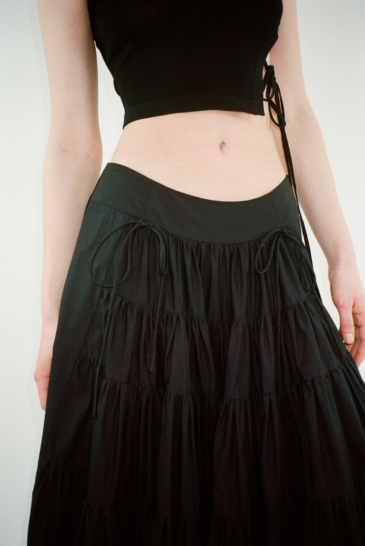 Midi length skirt in black with tiered construction on model