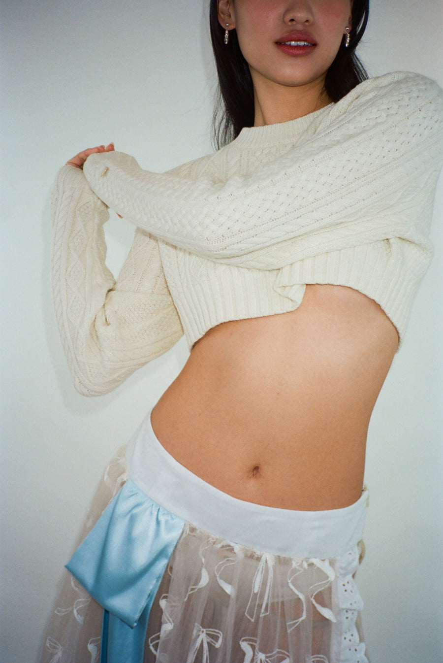Cropped cable knit sweater in off white on model