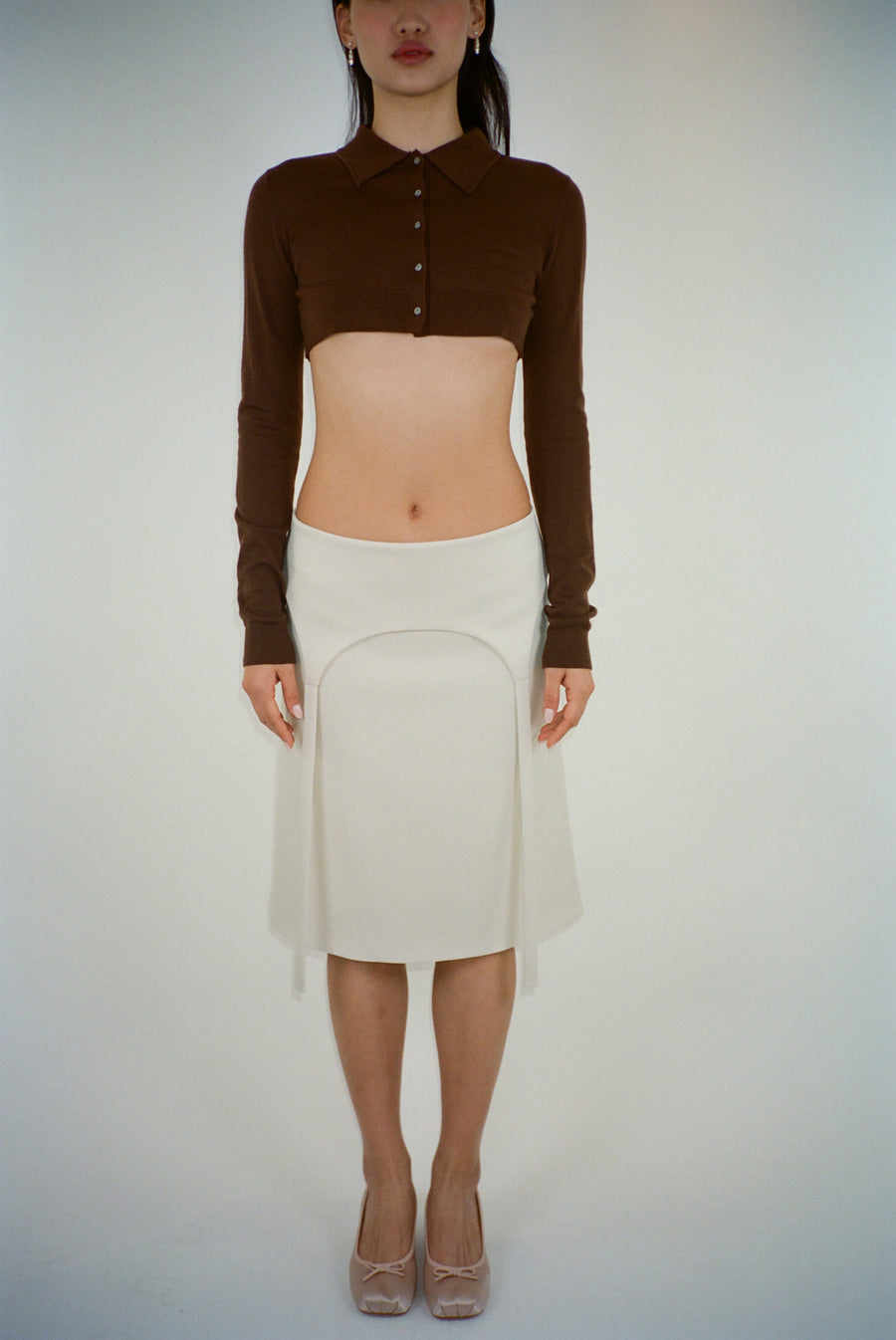 Knee length skirt in off white with garter strap detail on model