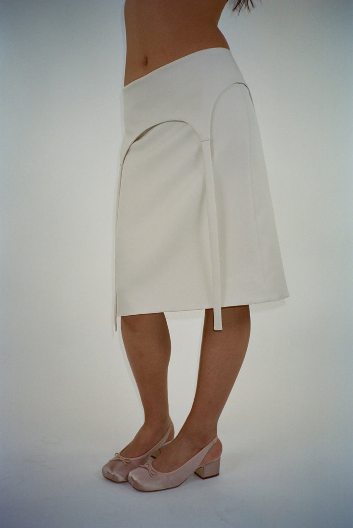 Knee length skirt in off white with garter strap detail on model