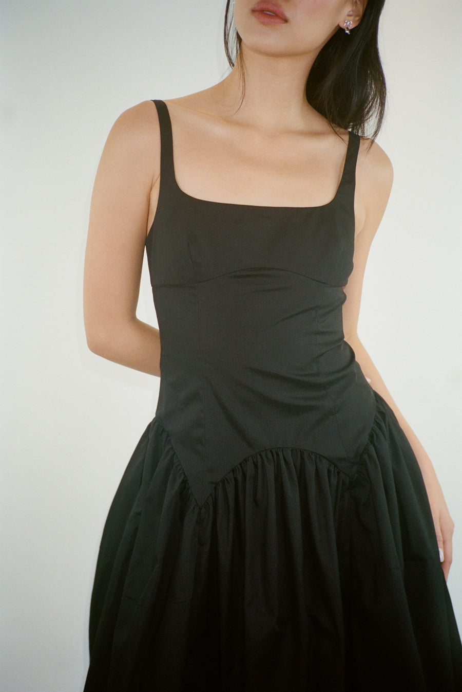 Sleeveless midi length dress in black with ties at back on model