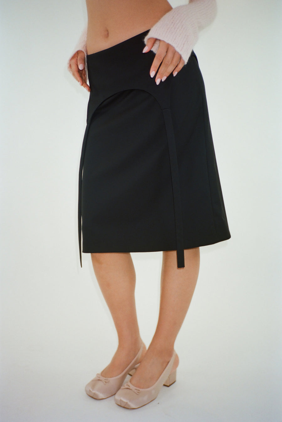 Knee length skirt in black with garter strap detail on model