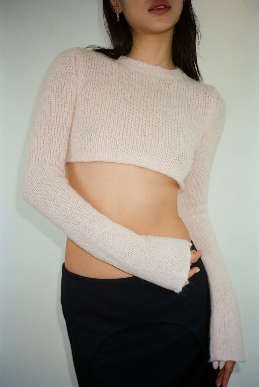 Cropped knit sweater in blush pink on model
