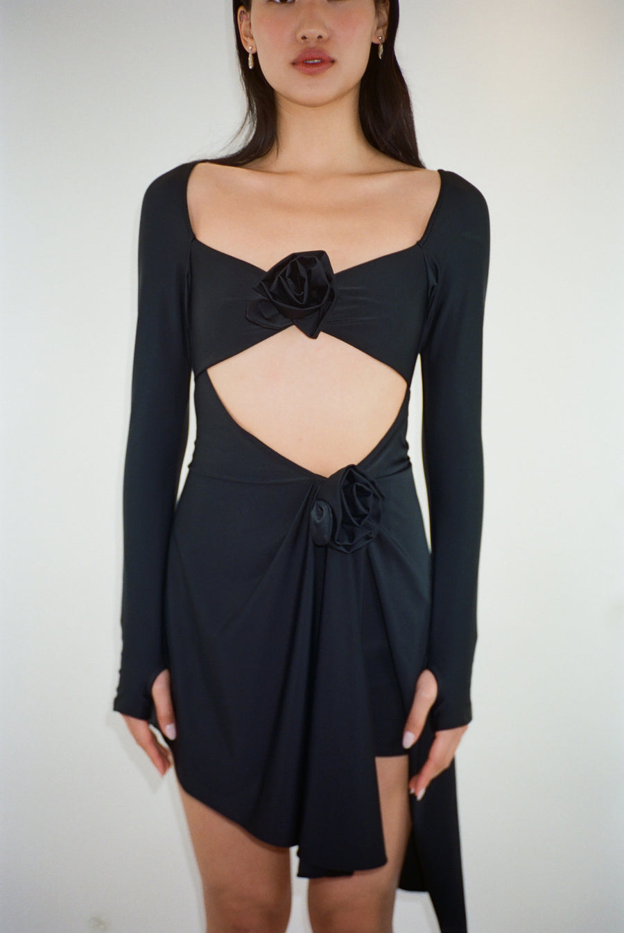 Asymmetric mini dress in black with rosette details on model