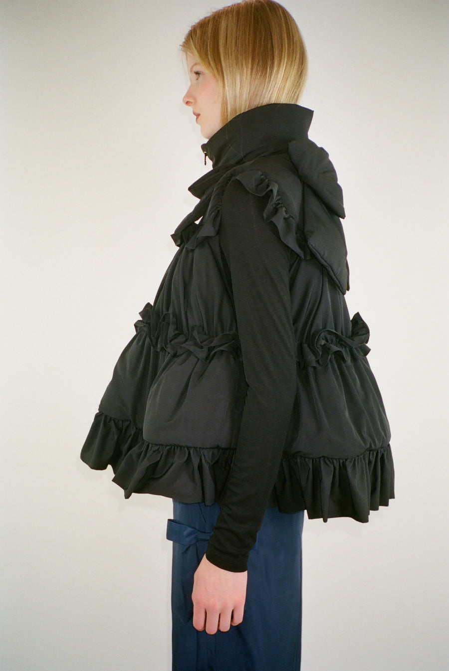 Puffer vest in black with ruffle details on model